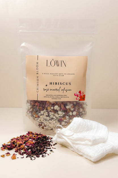 Bag of hibiscus and rose bath tea with a white towel on a light background, featuring the brand 'Löwin'.