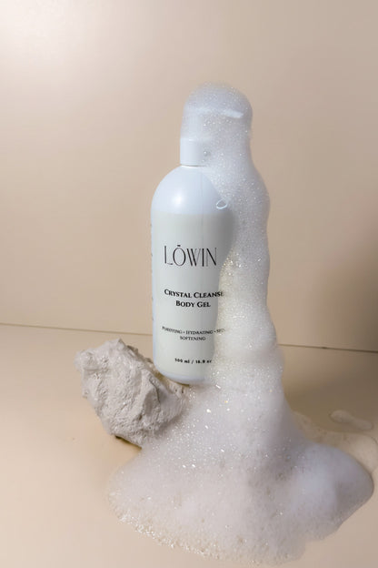 Löwin crystal cleansing body gel bottle with foam on a beige background