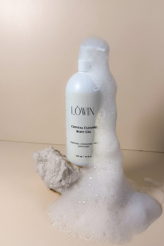 Löwin crystal cleansing body gel bottle with foam on a beige background