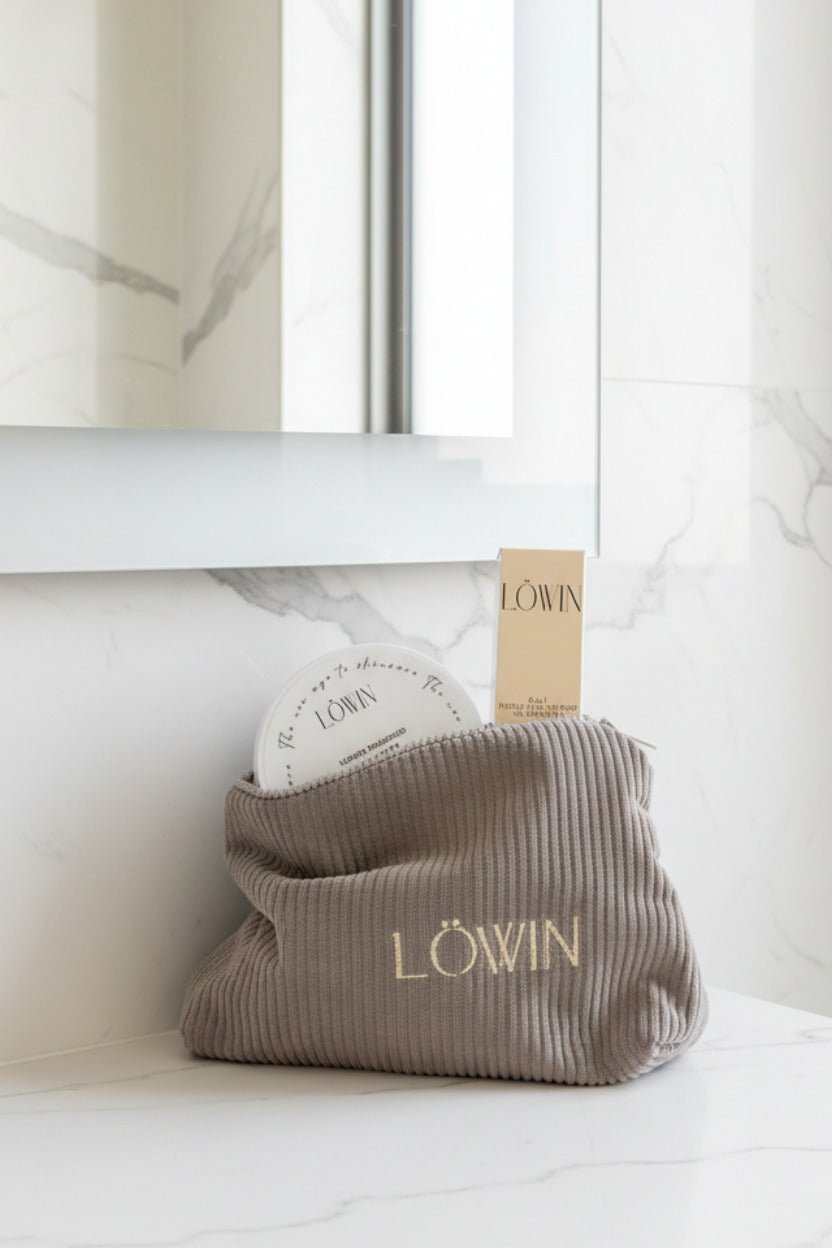 Corduroy toiletry bag with 'Löwin' branding on a bathroom counter.