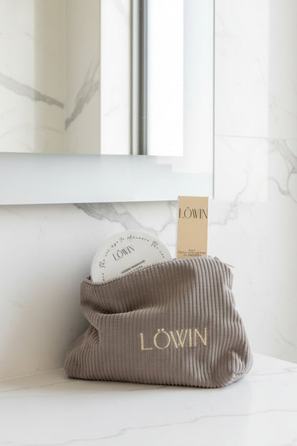 Corduroy toiletry bag with 'Löwin' branding on a bathroom counter.