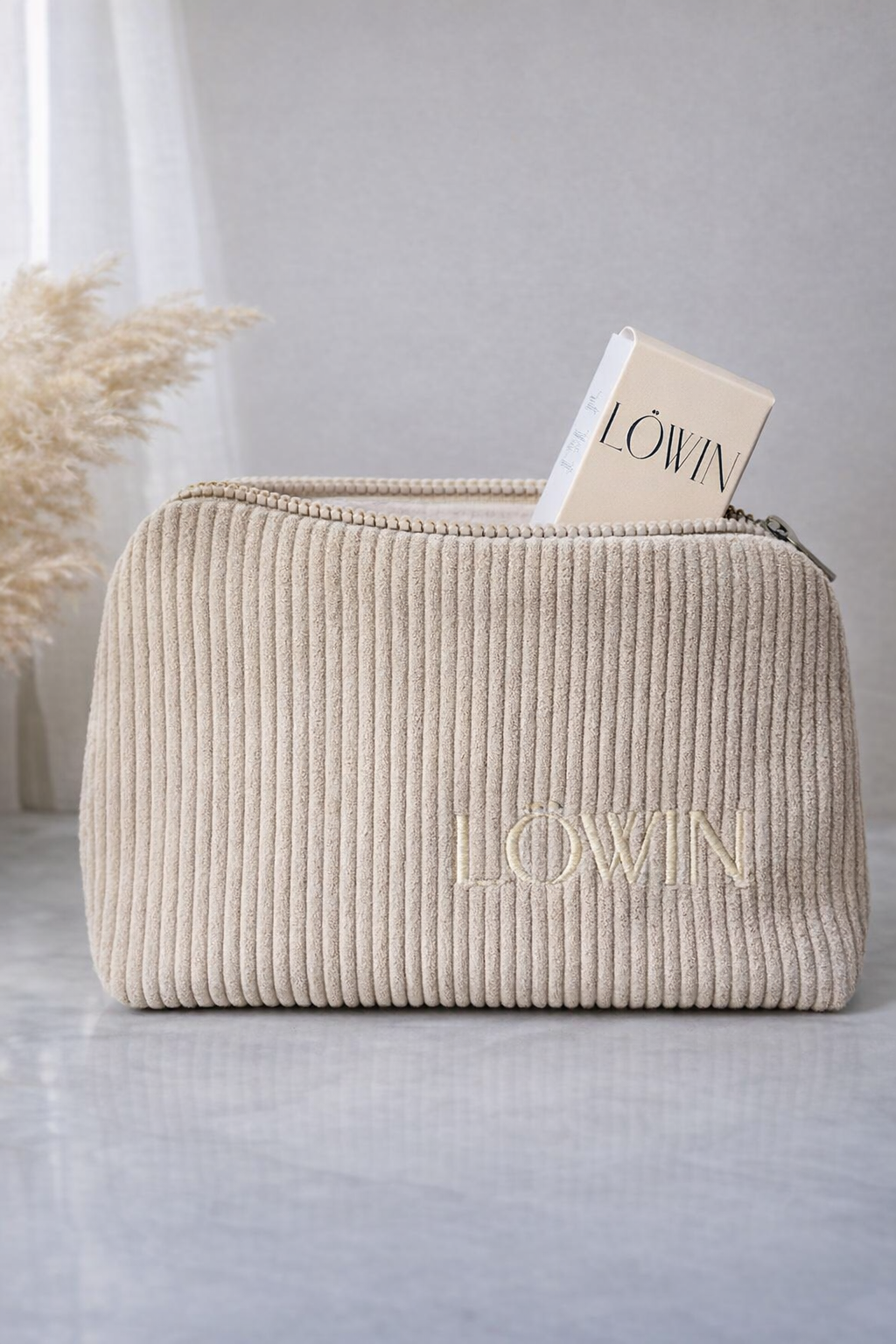 Beige corduroy bag with 'Löwin' branding on a light gray surface.