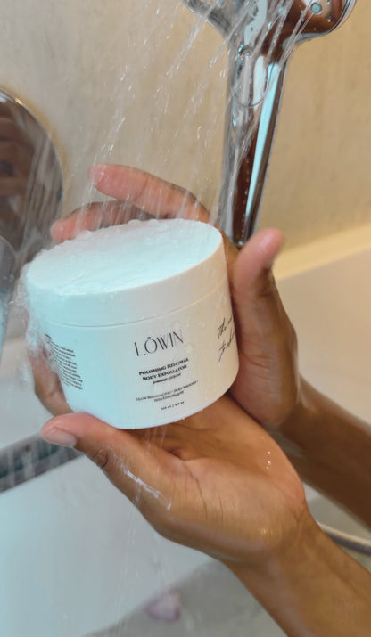 Hand holding the Löwin Body Polish under running water.