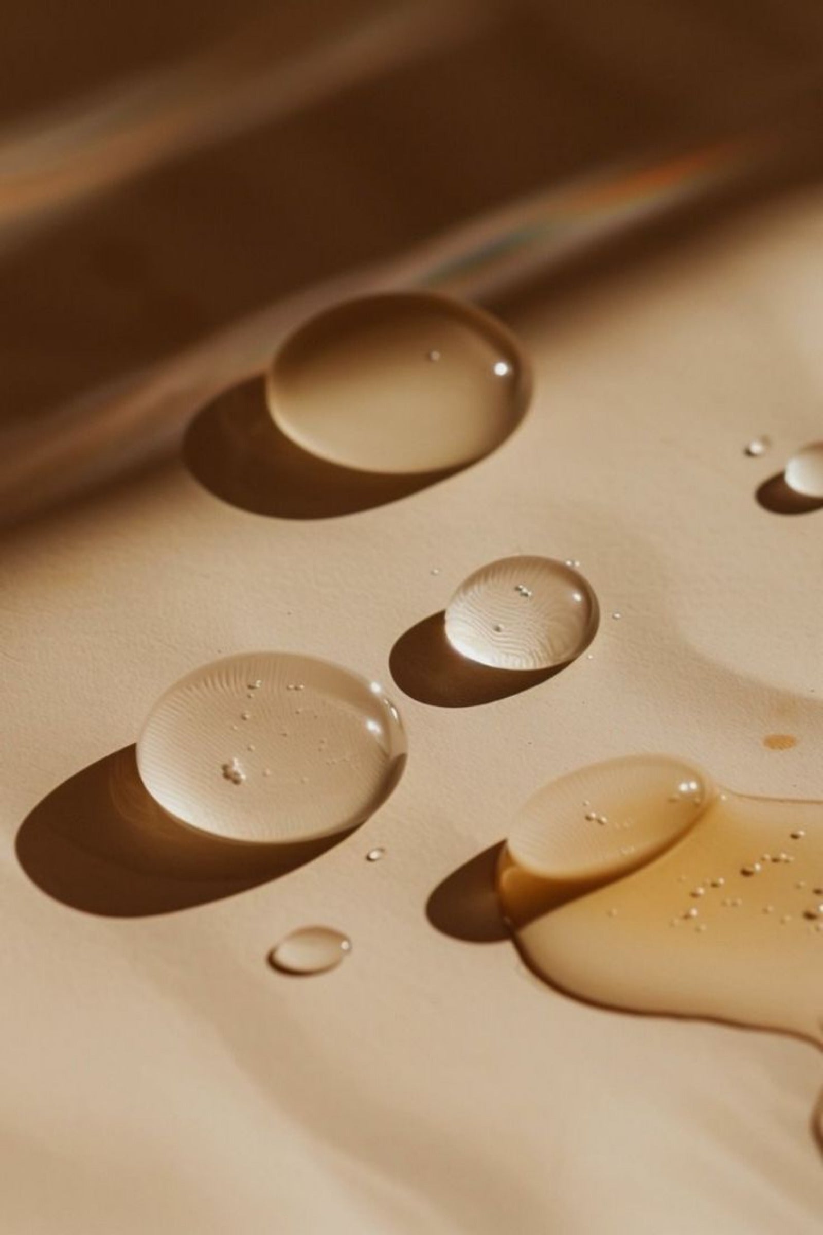 Close-up of water droplets on a textured surface with a warm color palette.
